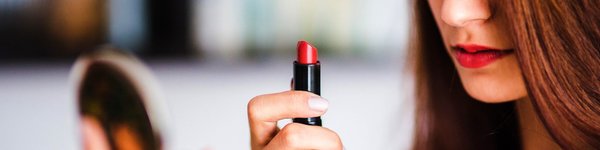 Natural products for the skin. Girl, look at the red lipstick which has just colored your lips a beautiful red.